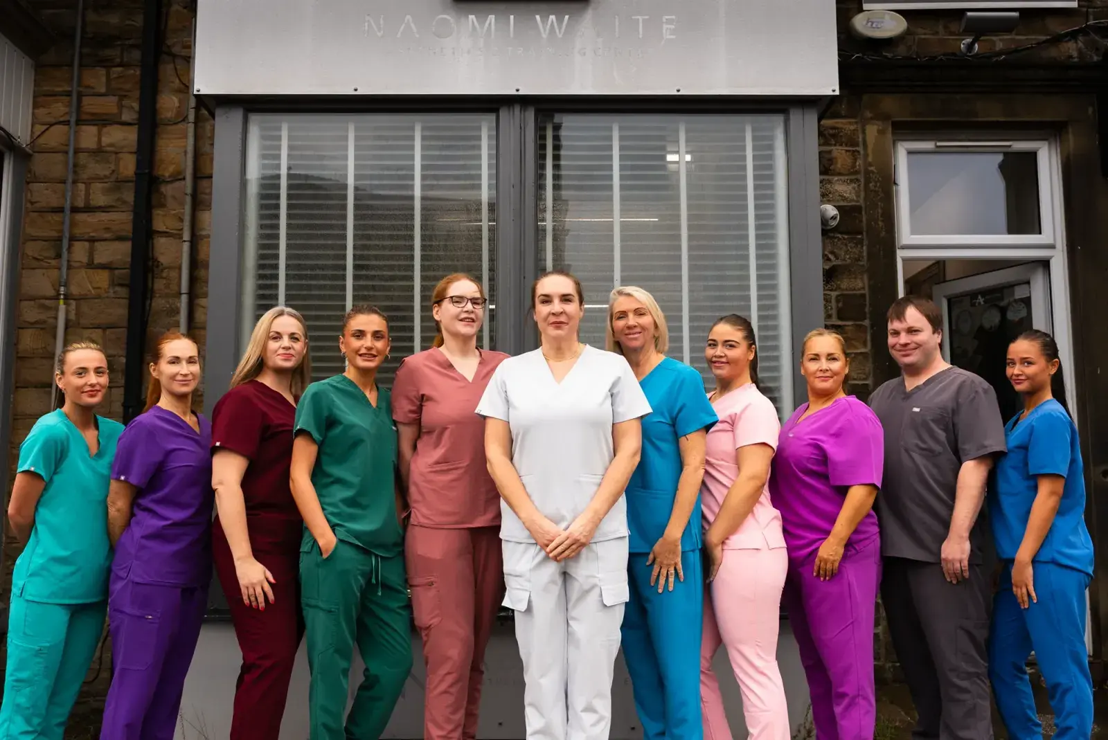 The Naomi Waite Aesthetics team standing together in front of the clinic
